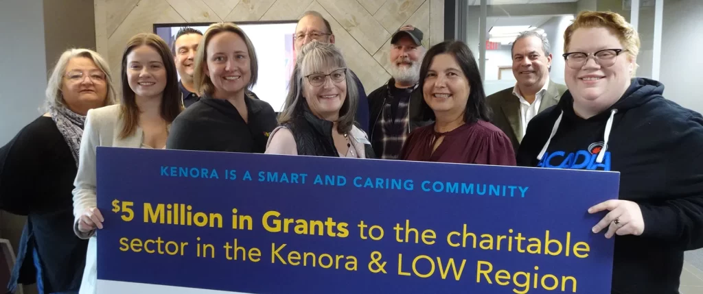 Staff and Board of KLWCF hold up a sign showing $5 million in grants