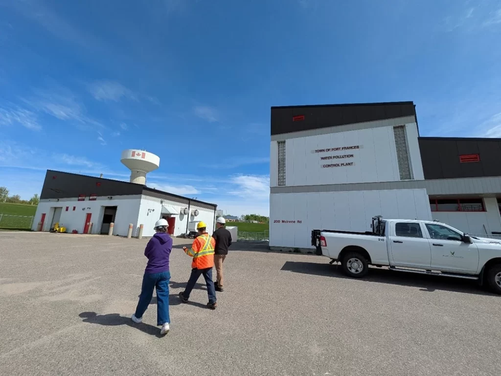 People walk through the parking lot of a Pollution Control Plant